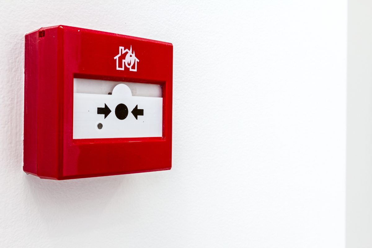 Red fire alarm call point on a commercial wall